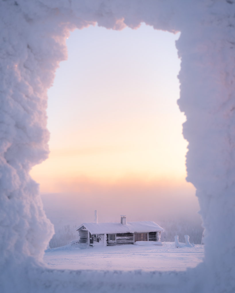 A snow covered hut in Finland in the winter, framed by snow