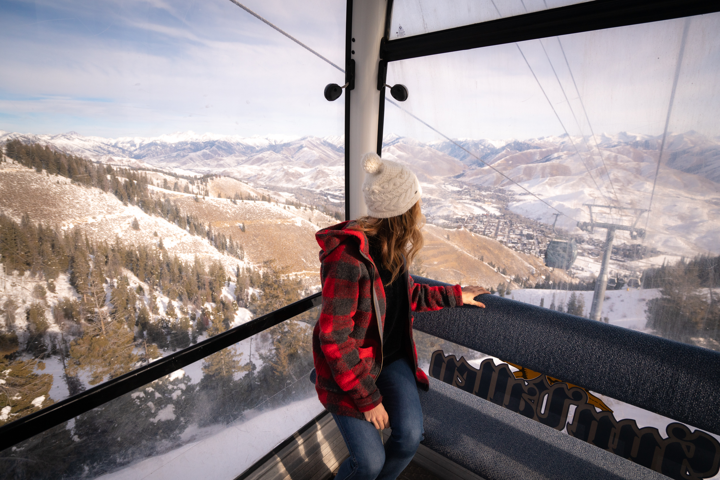 Jess riding up the mountain in a gondola with a view of the mountains