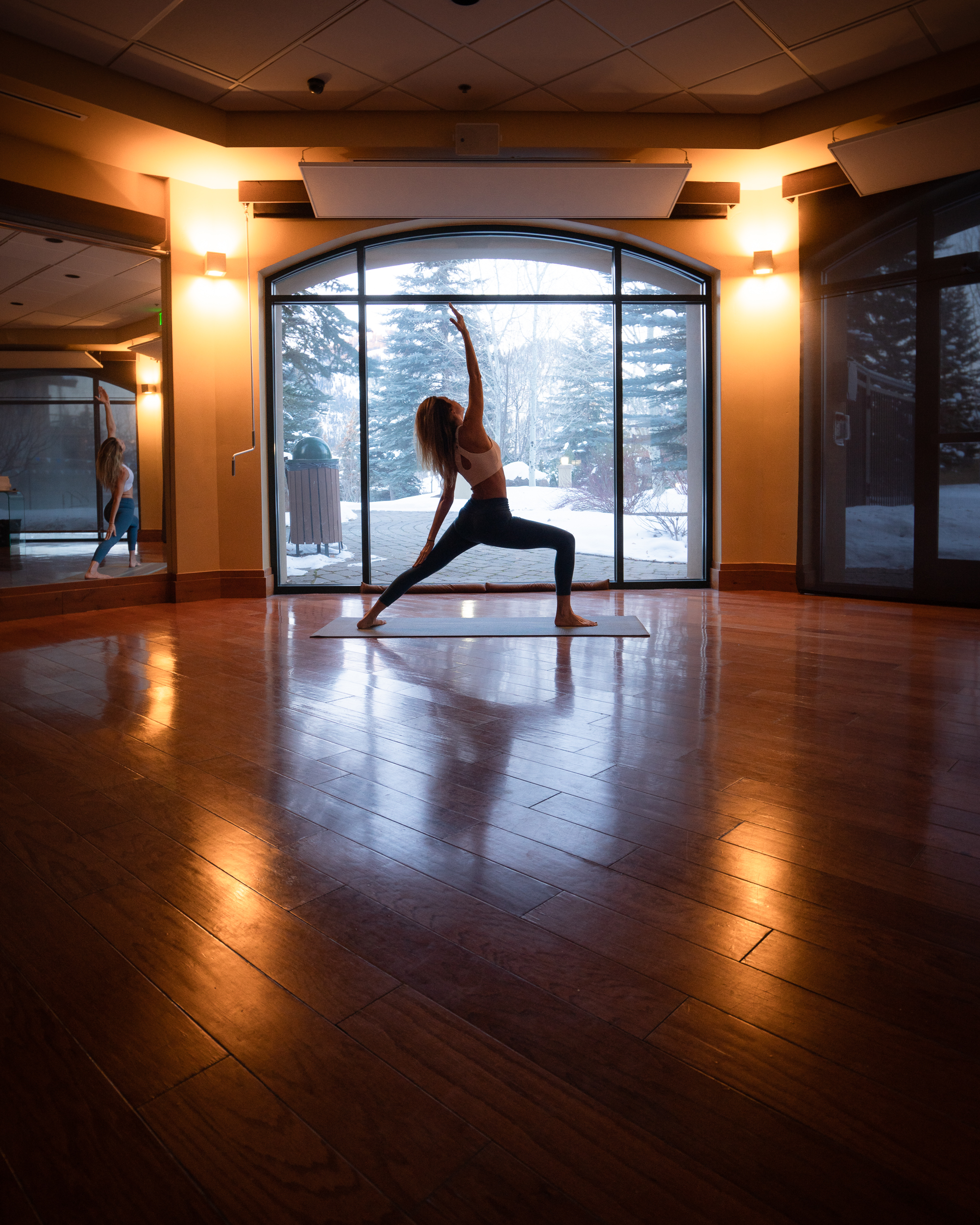 Jess doing yoga in the yoga studio at Zenergy in Sun Valley, Idaho with a snowy scene outside the window