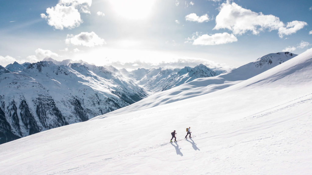 two men hiking on snowy mountain