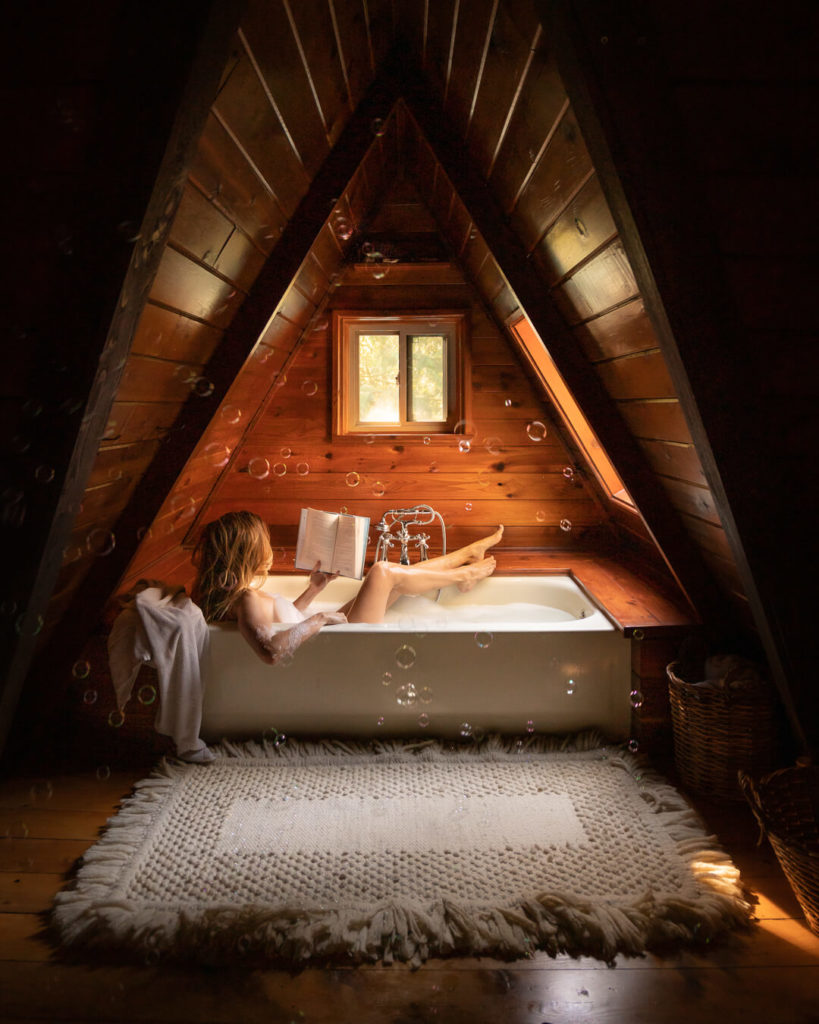 Jess Wandering in bathtub at Welches A-Frame cabin near Mount Hood, one of the best cozy pacific northwest cabins in Oregon