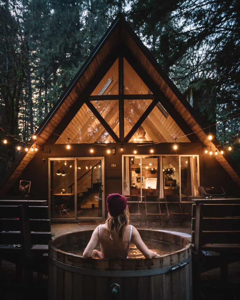Jess Wandering relaxing in hot tub at Chateau Marmot cabin in Pacific Northwest