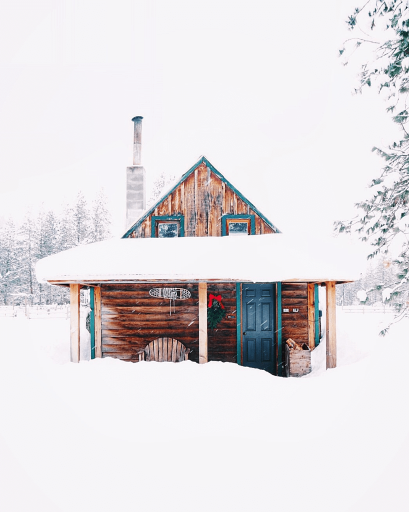 a wooden cabin covered in snow