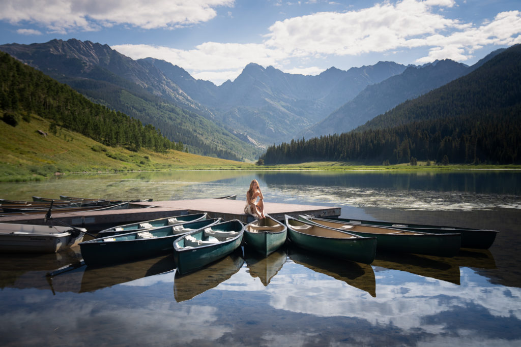 Girl sitting on dock at Piney River Ranch outside of Vail, Colorado.