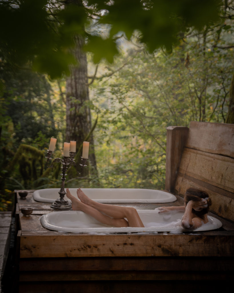 jess wandering using the outdoor bathtubs at heartland treehouse, one of the best pnw cabins to rent for outdoor lovers