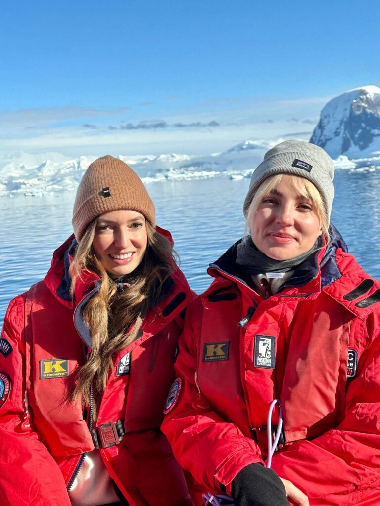 Two women in red jackets on board a zodiac in Antarctica