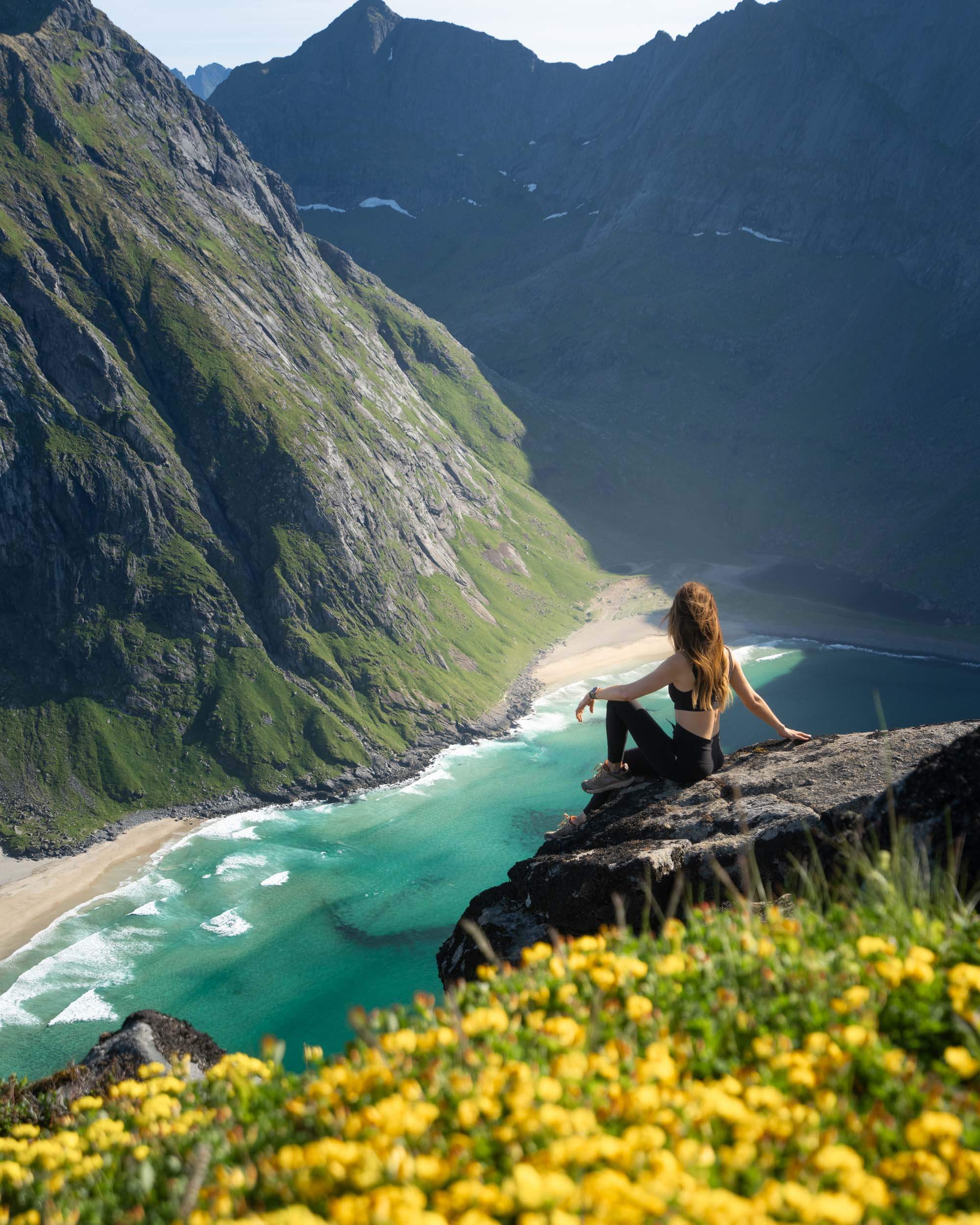 Jess Wandering enjoying the view of Kvalvika Beach from the Ryken trail, one of the best hikes in the Lofoten Islands