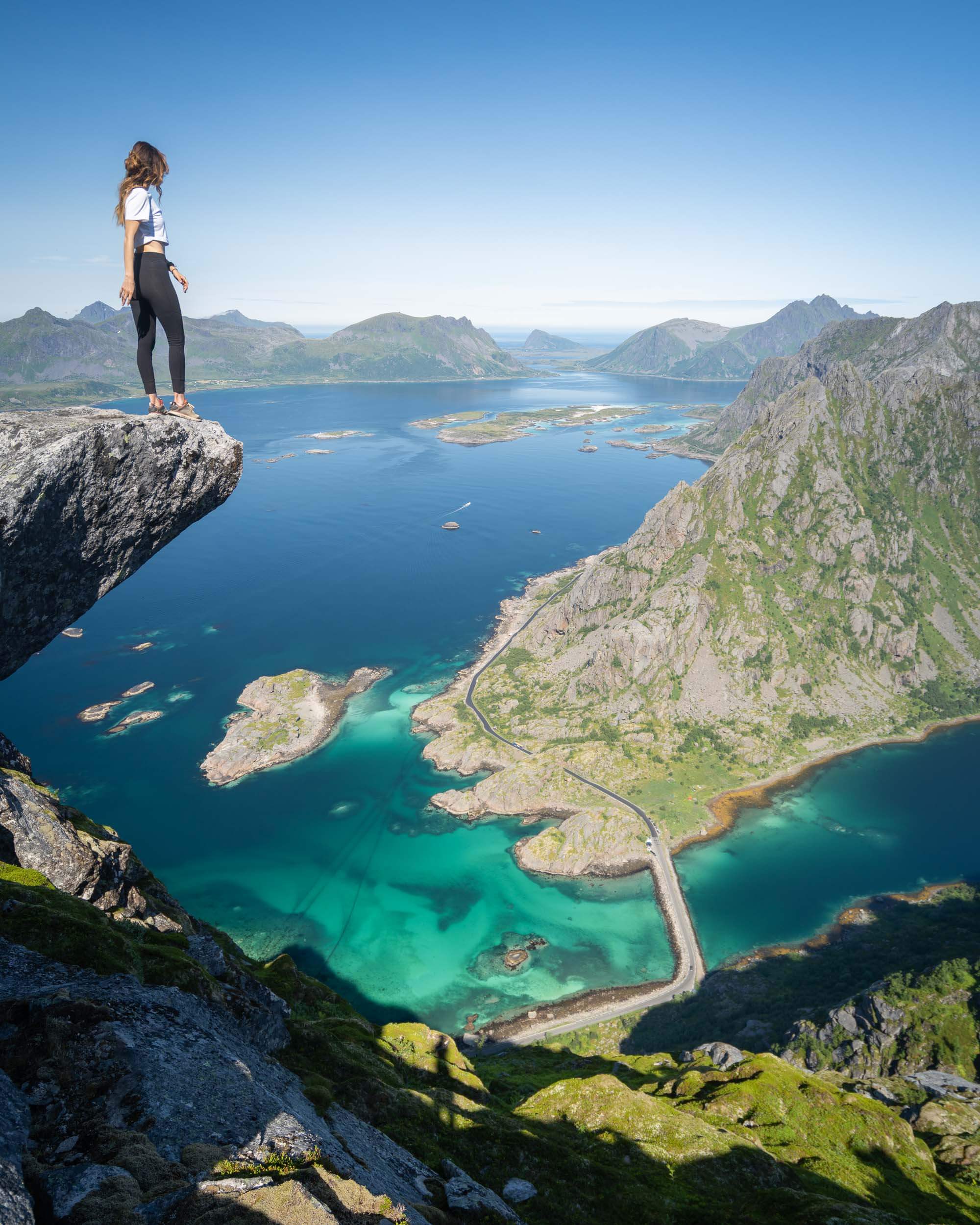 Jess Wandering standing on a rock overlooking the blue water and islands from Torsketunga hike in Norway